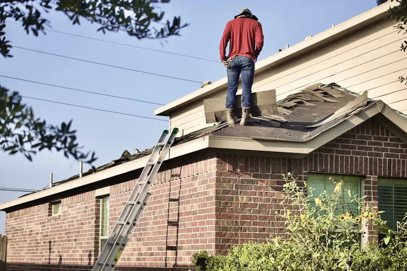 Professional roofer working on a residential roof in Rulon Road